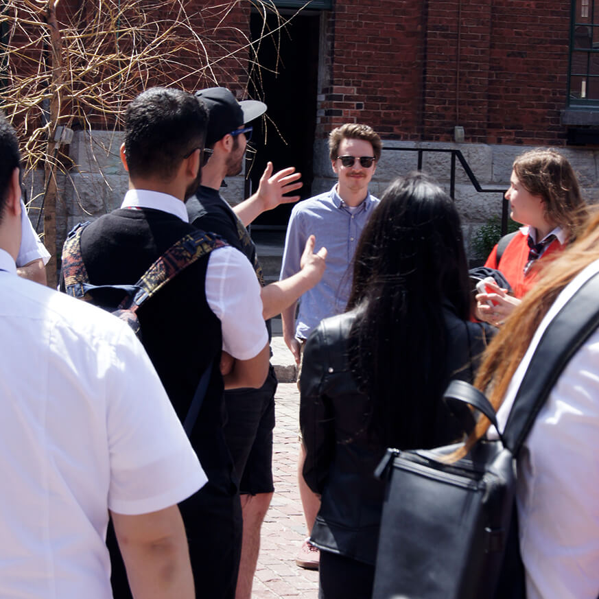 A guide with a group on a walking tour in Toronto's Distillery District