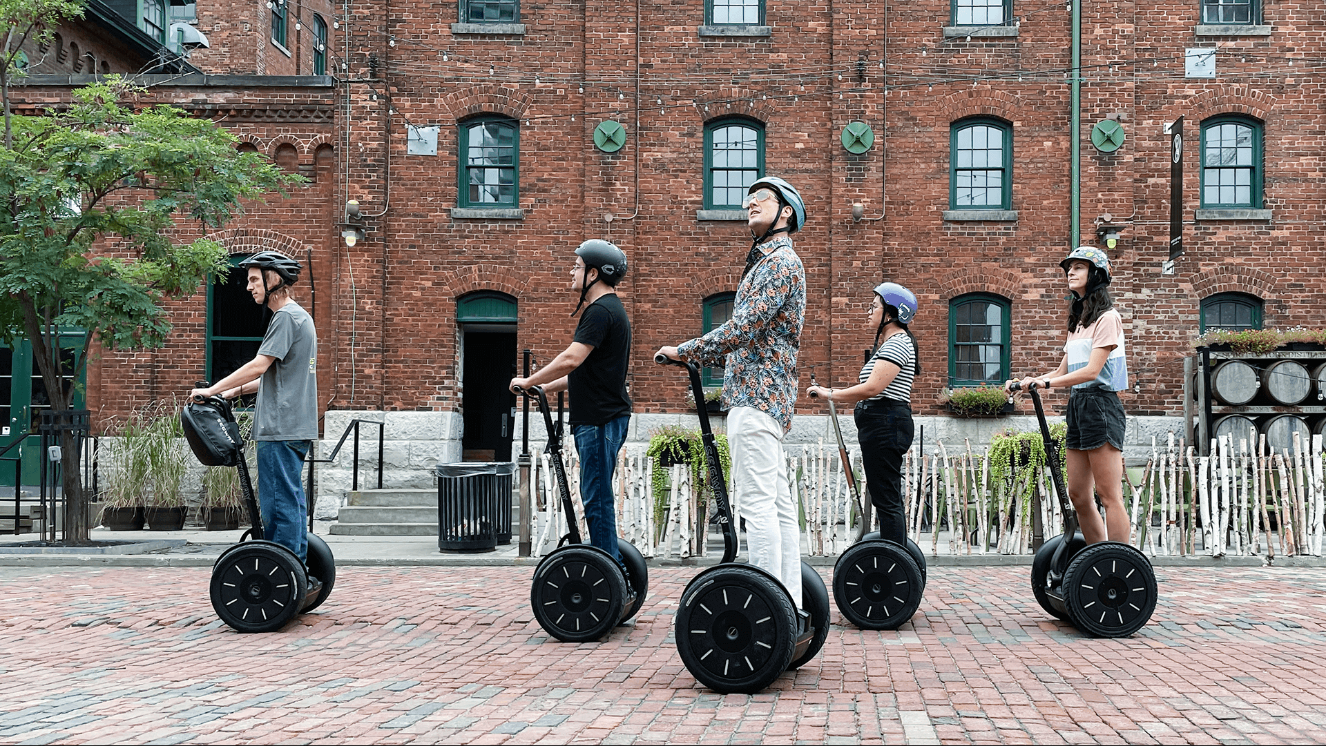 A guide talking to a small walking tour group on a cobbled lane in Toronto's Distillery District